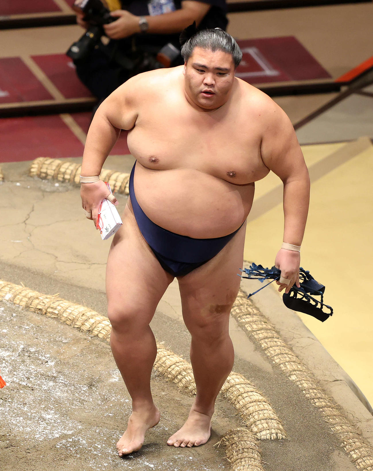 懸賞金の束を手に土俵を引き揚げる御嶽海（撮影・鈴木正人）