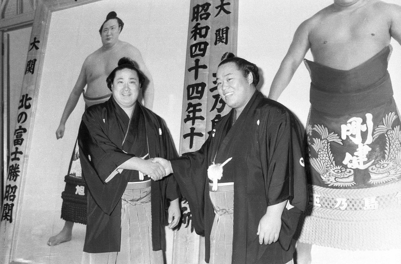 1970年1月、初場所前日、優勝額の前で握手する北の富士（左）と玉乃島（玉の海）