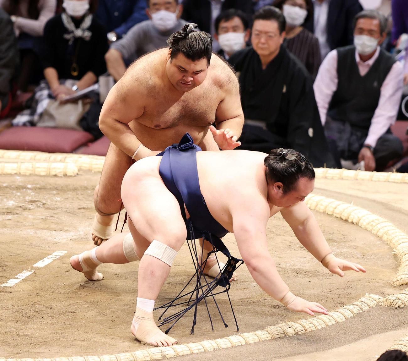 宝富士（手前）を下手出し投げで破る高安（撮影・鈴木正人）