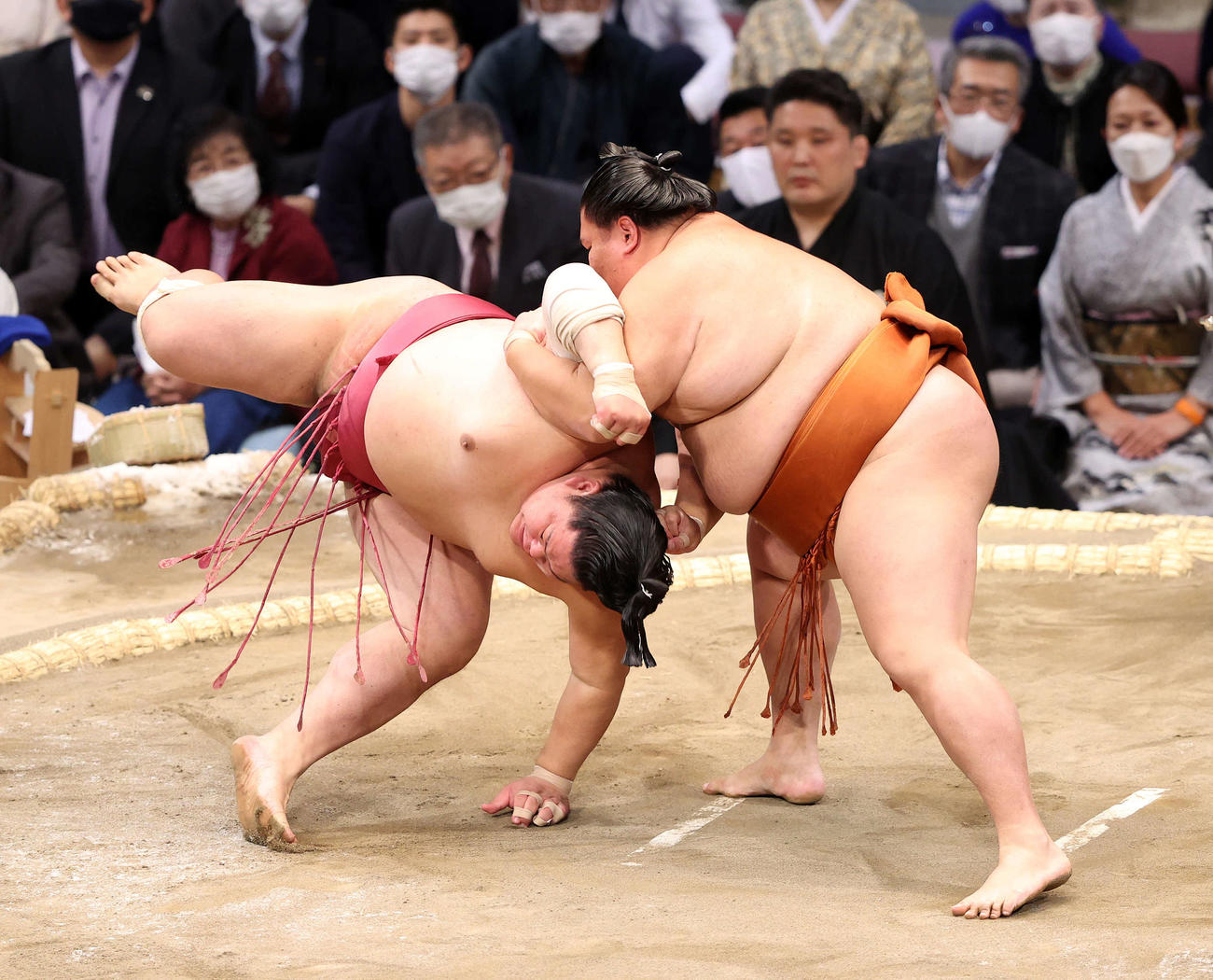 大栄翔（左）をすくい投げで破る御嶽海（撮影・鈴木正人）