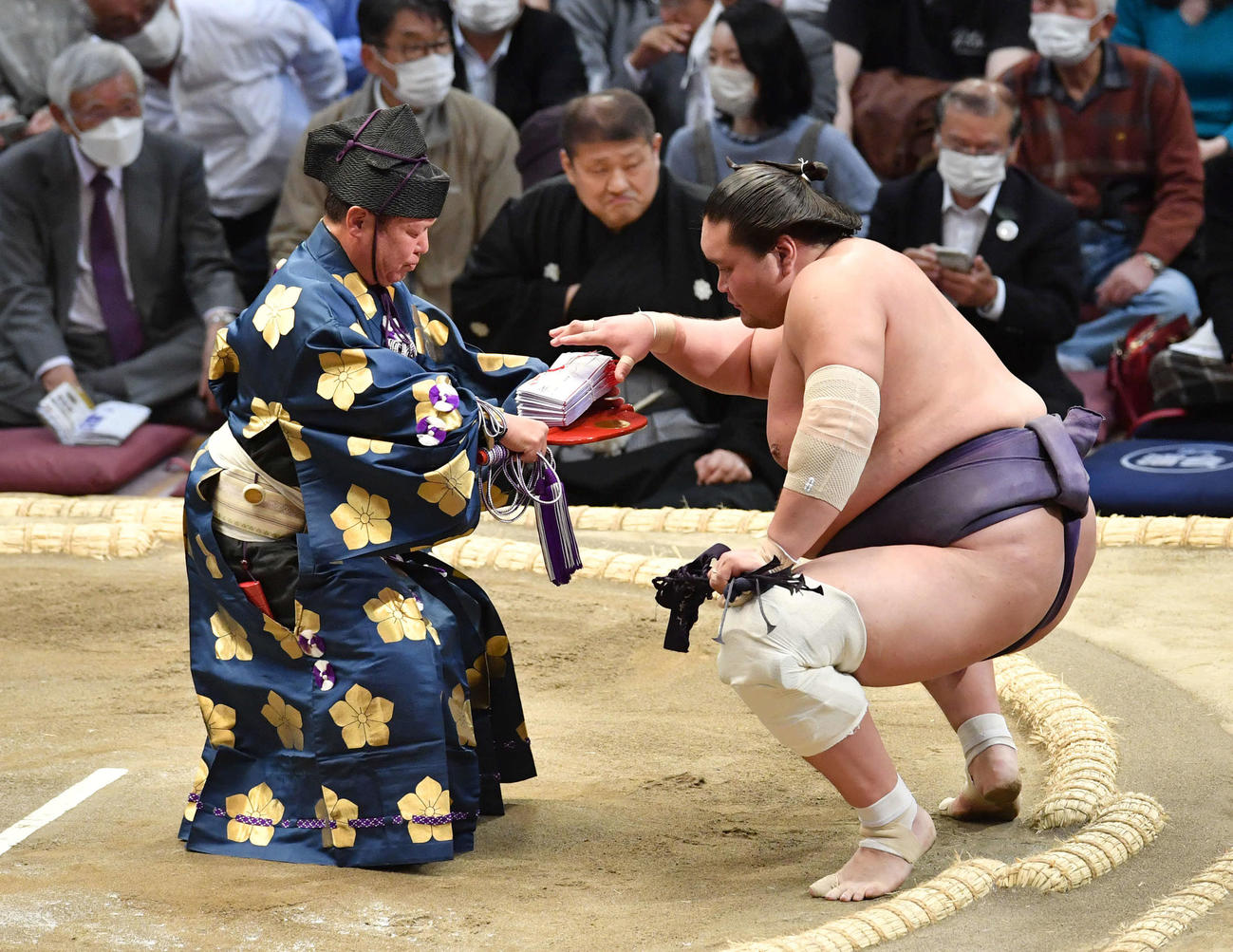 若隆景を押し出しで破り、懸賞を受け取る照ノ富士（撮影・岩下翔太）