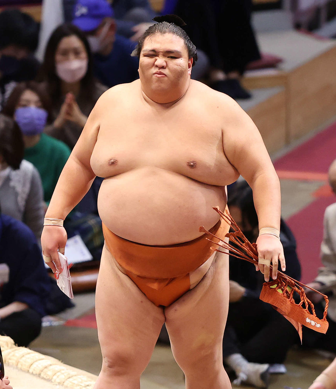 懸賞金を手に土俵を引き揚げる御嶽海（撮影・鈴木正人）