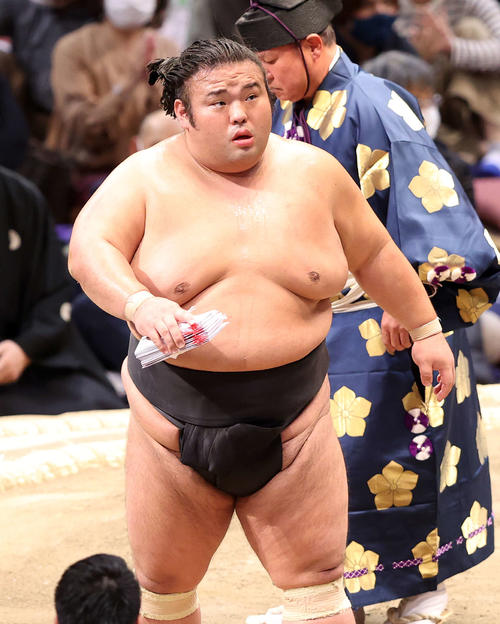 懸賞金の束を手に土俵を引き揚げる貴景勝（撮影・鈴木正人）
