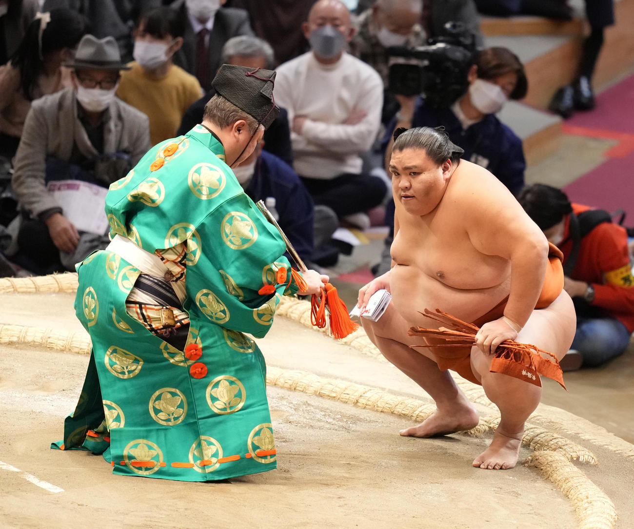 勝ち越しを決めた御嶽海（右）は懸賞金を手にする（撮影・小沢裕）