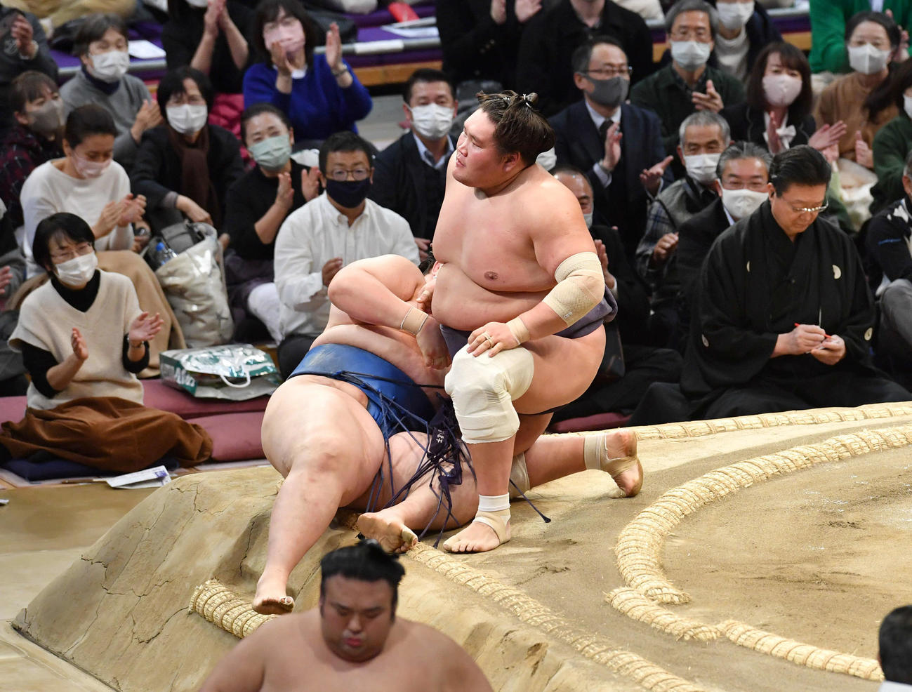 照ノ富士は逸ノ城（左）を寄り倒しで破る、手前は引き揚げる貴景勝（撮影・岩下翔太）