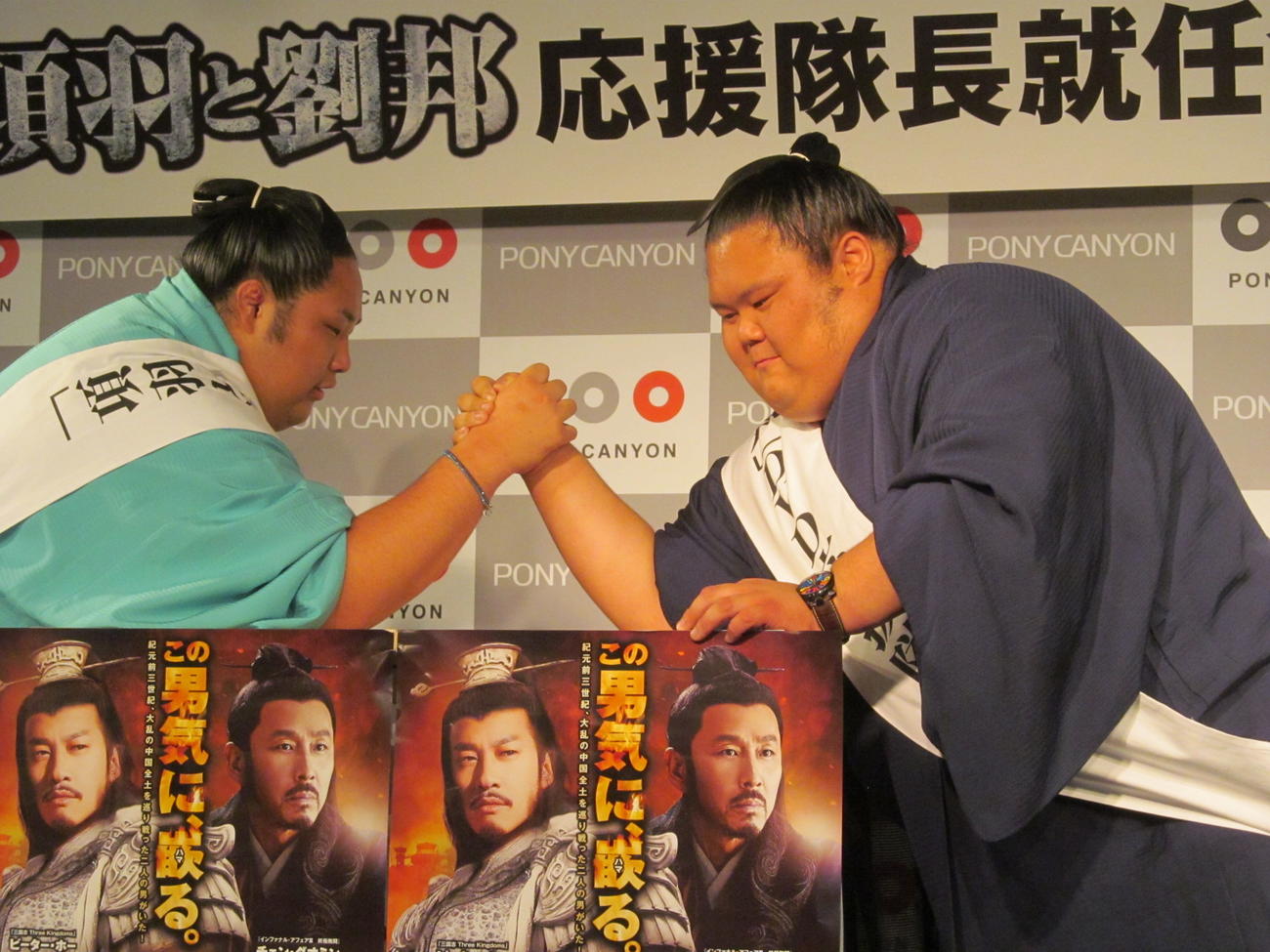 腕相撲を取る兄の千代丸（右）と弟の千代鳳（2014年6月17日撮影）