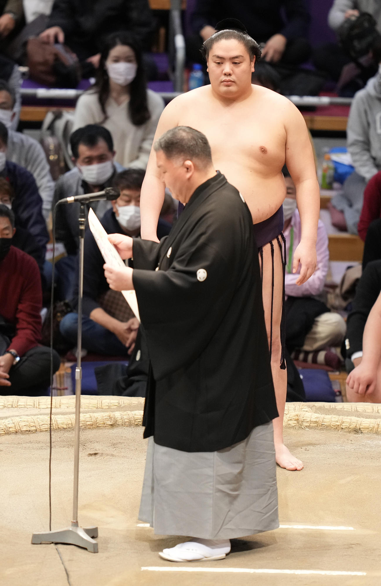 十両優勝を飾り表彰式に臨む一山本。手前は高田川審判部副部長（撮影・小沢裕）