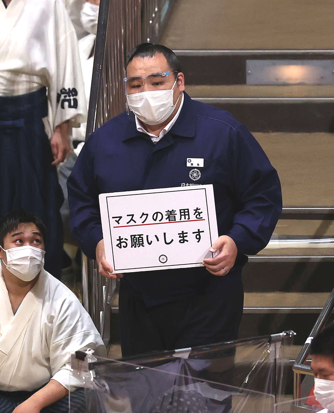 夏場所で注意喚起のボードを手に館内を回る鶴竜親方（2021年5月21日撮影）