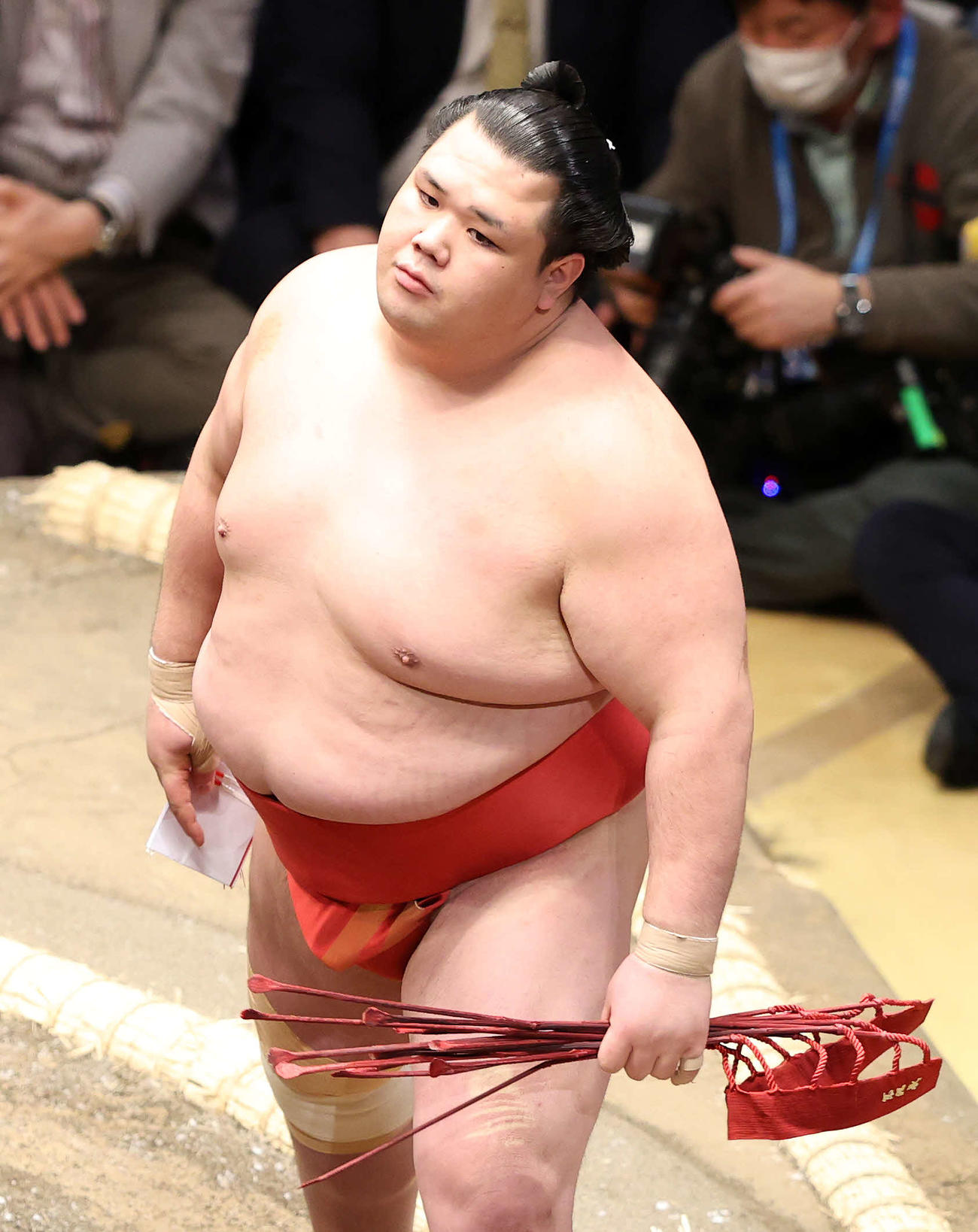 懸賞金を手に土俵を引き揚げる阿武咲（撮影・鈴木正人）