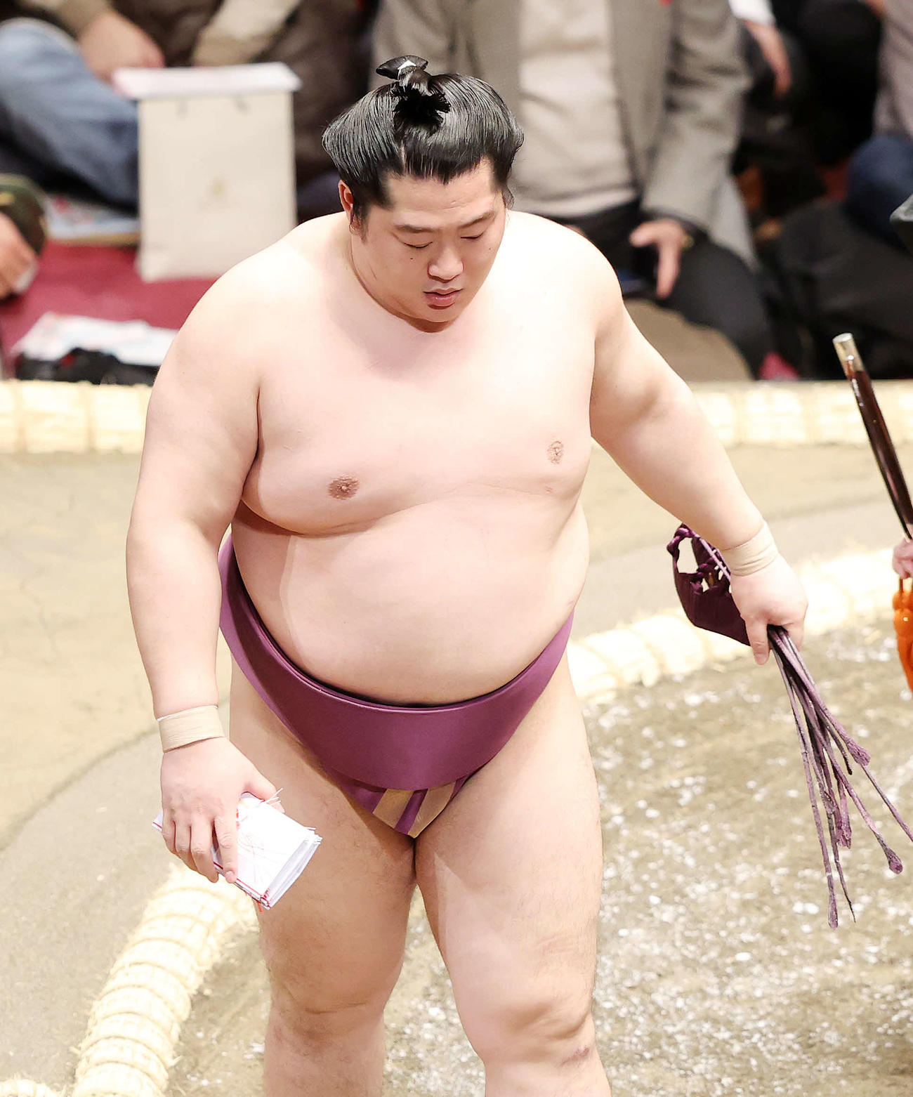 懸賞金の束を手に土俵を引き揚げる遠藤（撮影・鈴木正人）