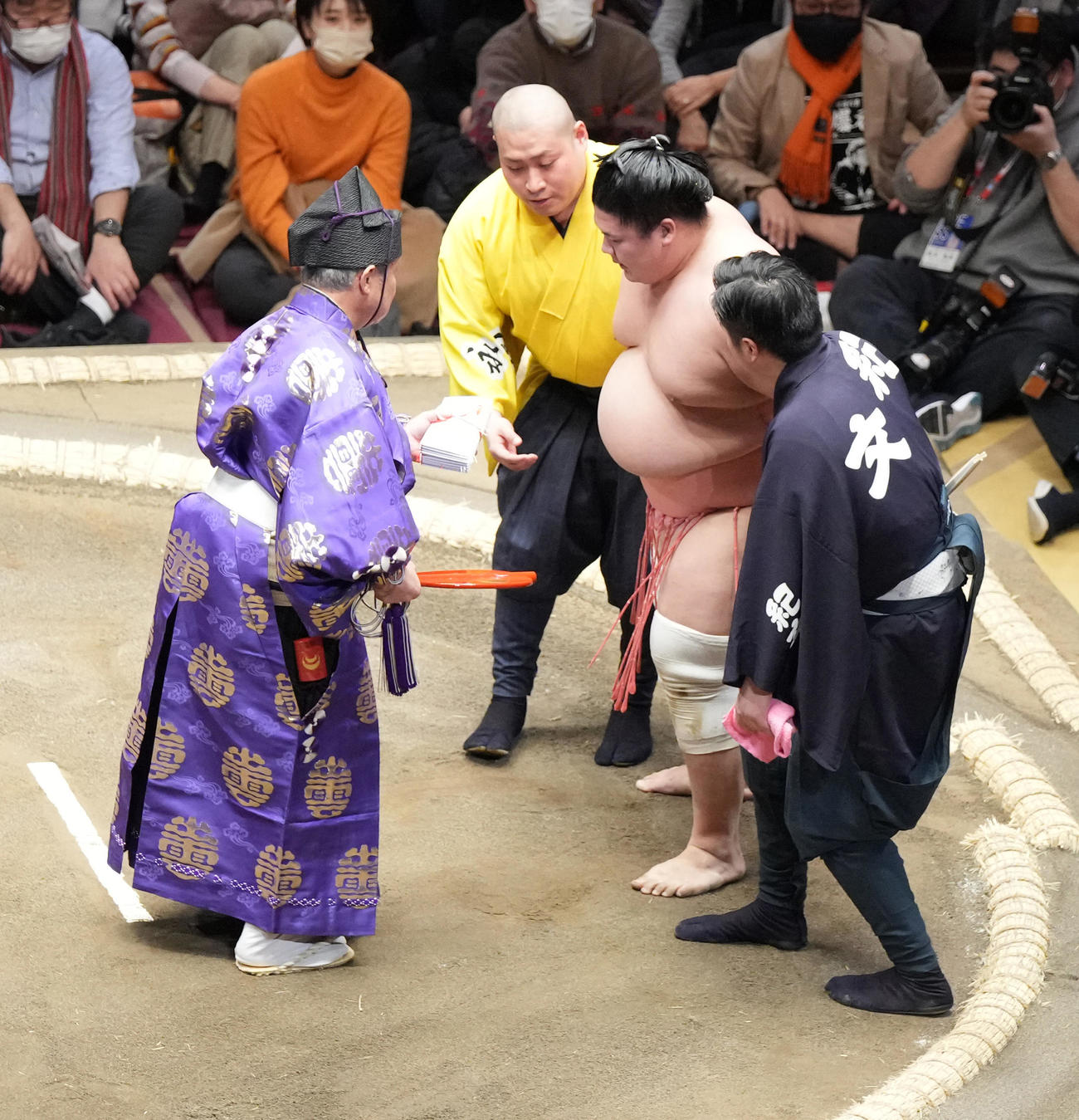 呼出らに土俵から下りるよう説得される宇良。行司の式守伊之助も懸賞金を手に促す（撮影・小沢裕）