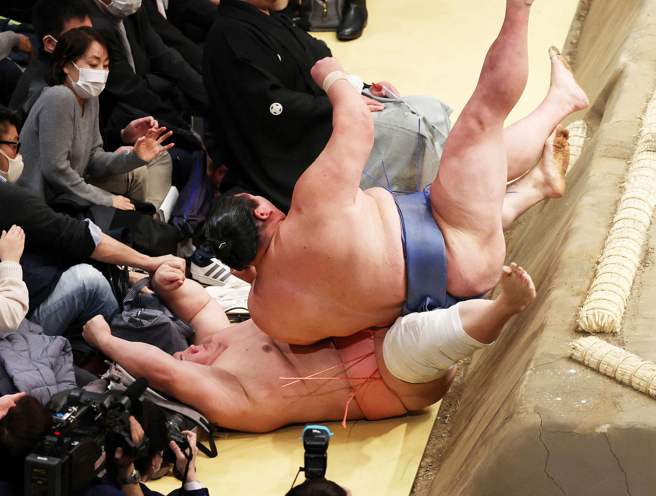 土俵下に押し出しされた宇良の上に勢い余った正代が落ちる（撮影・鈴木正人）