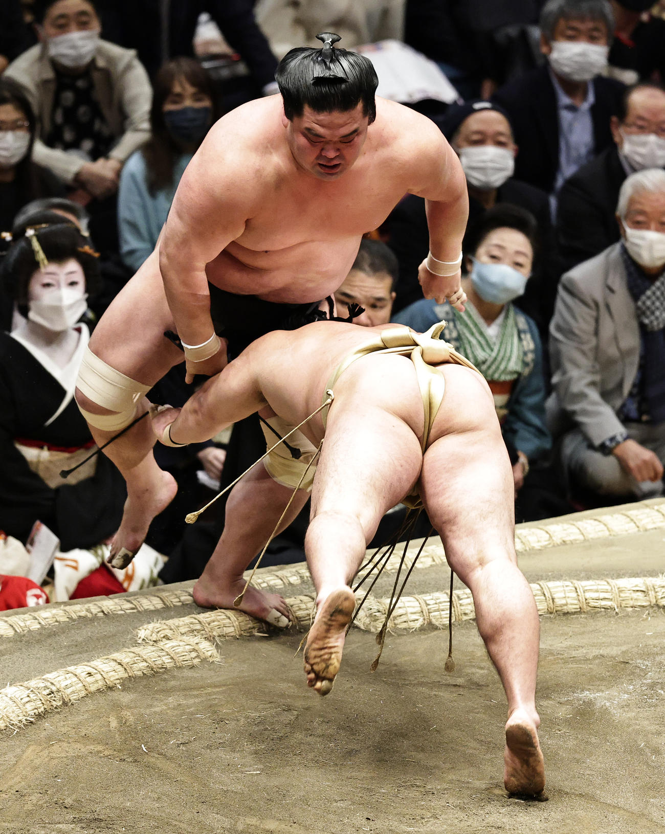 妙義龍（上）を押し出しで破る石浦（撮影・中島郁夫）