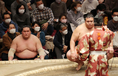 御嶽海（手前右）が全勝を守って勝ち名乗りを受け、土俵下で厳しい表情を見せる照ノ富士（撮影・河野匠）