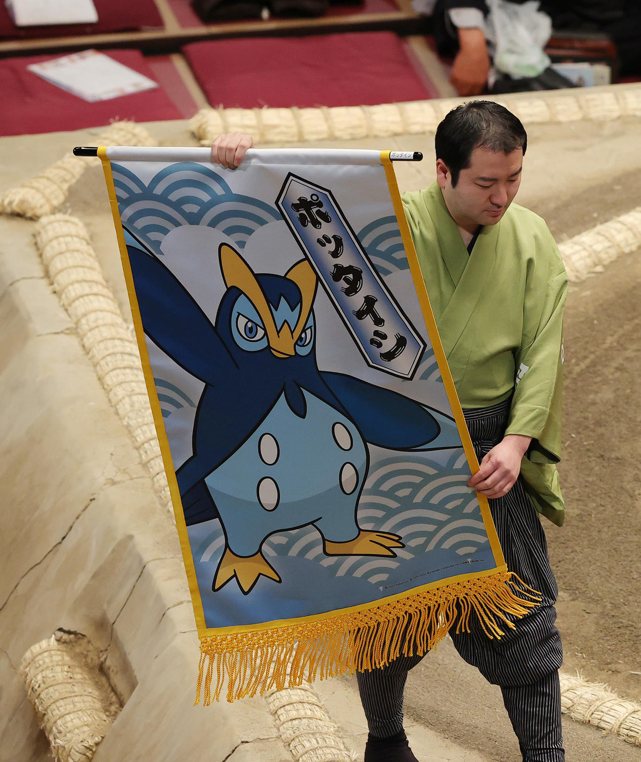 琴勝峰と剣翔の取組に懸けられた、ペンギンポケモン「ポッタイン」の懸賞幕（撮影・河野匠）