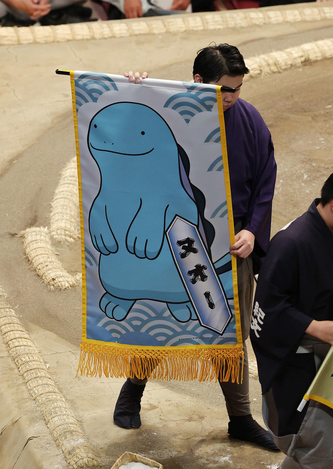 妙義龍と千代大龍の取組に懸けられた、みずうおポケモン「ヌオー」の懸賞幕（撮影・河野匠）