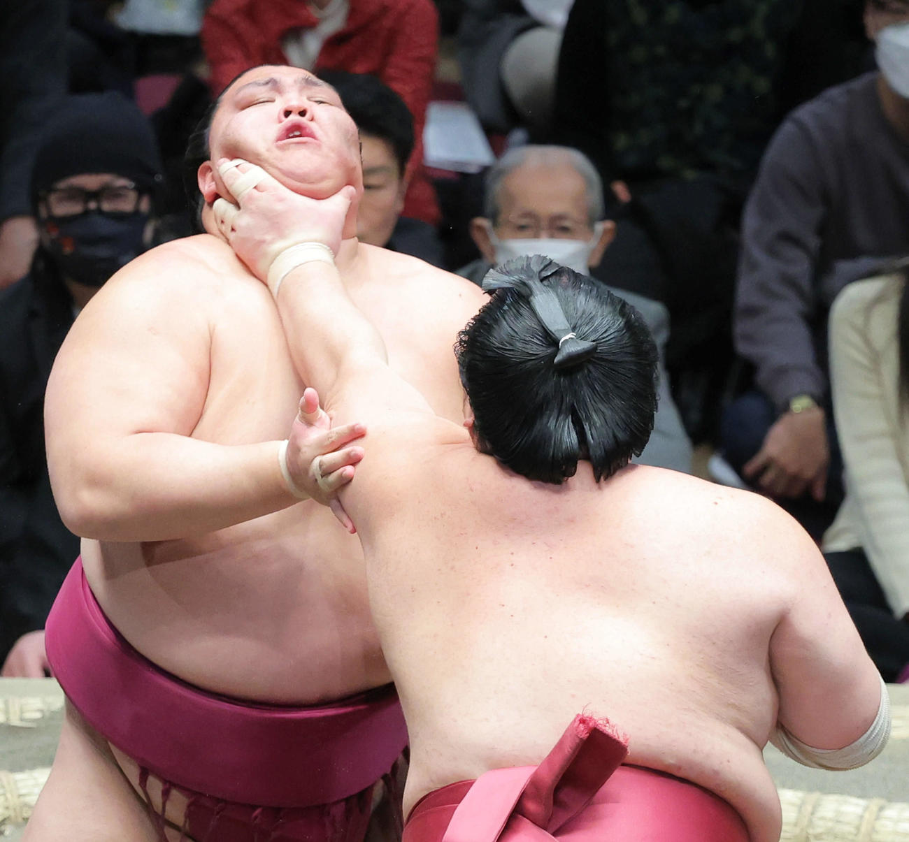大栄翔（手前）ののど輪に耐える御嶽海（撮影・河田真司）