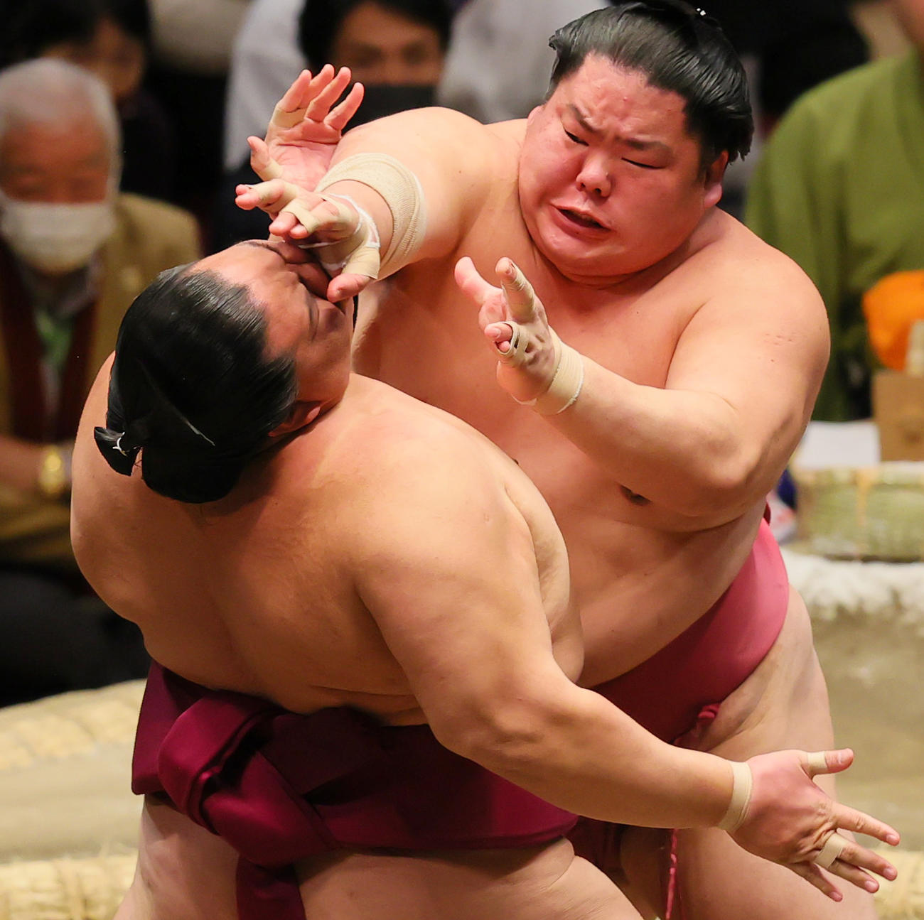 大栄翔（後方）の張り手をこらえる御嶽海（撮影・野上伸悟）