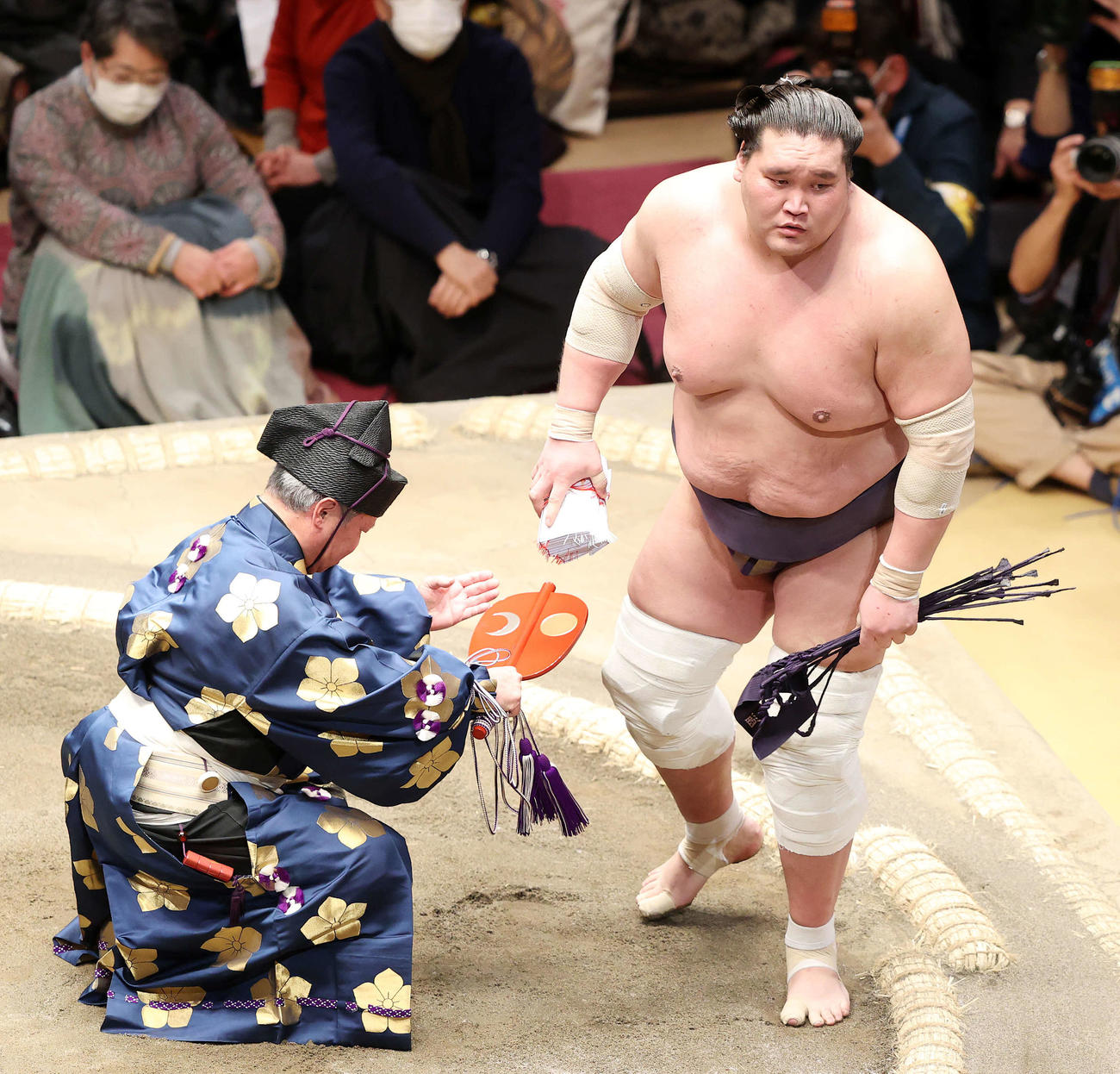 懸賞金の束を手に土俵を引き揚げる照ノ富士（撮影・鈴木正人）