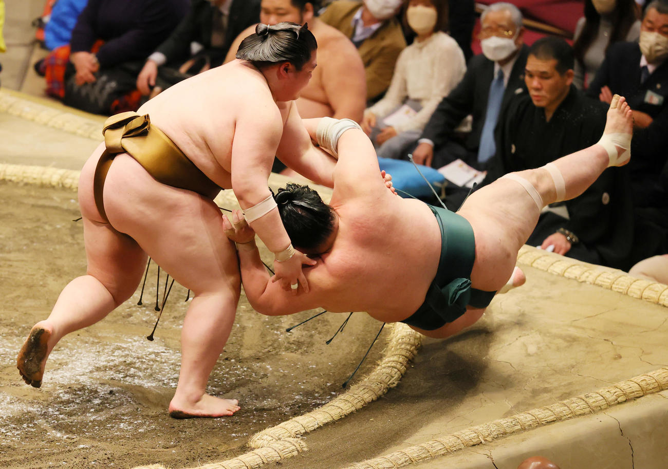 豊山（右）をすくい投げで破る王鵬（撮影・野上伸悟）