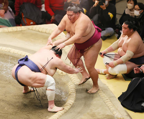 押し出しで北勝富士（左）に敗れる御嶽海。後方右は照ノ富士（撮影・野上伸悟）