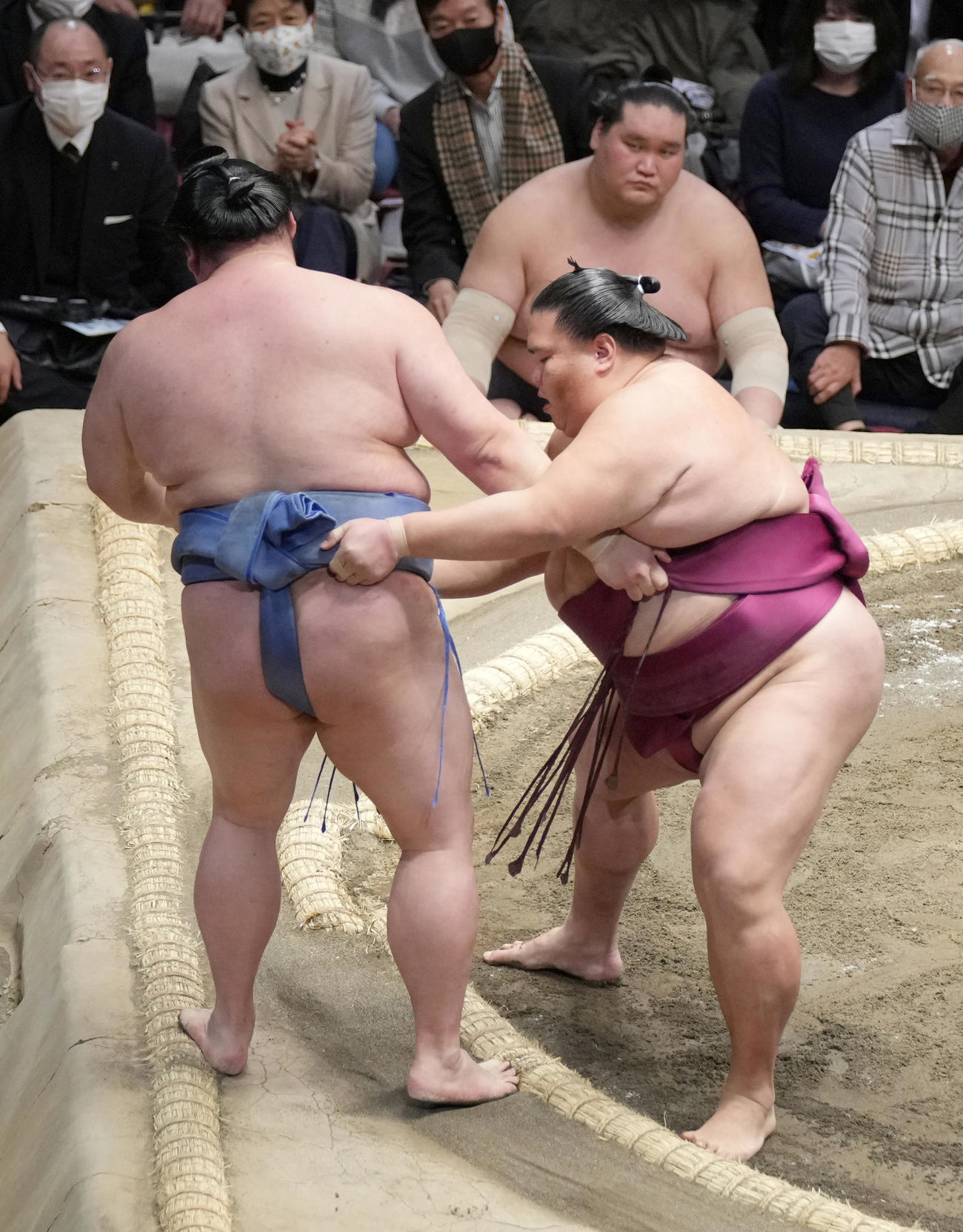 御嶽海は寄り切りで正代（左）を破る。右奥は照ノ富士（撮影・小沢裕）