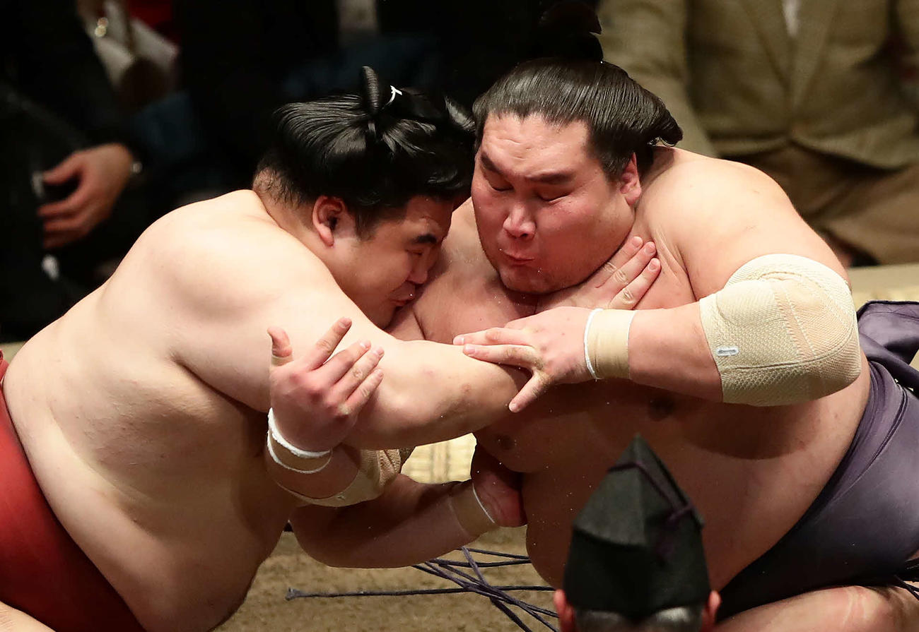 立ち合いに隆の勝（左）の右腕を抱え込みにいく照ノ富士（撮影・丹羽敏通）