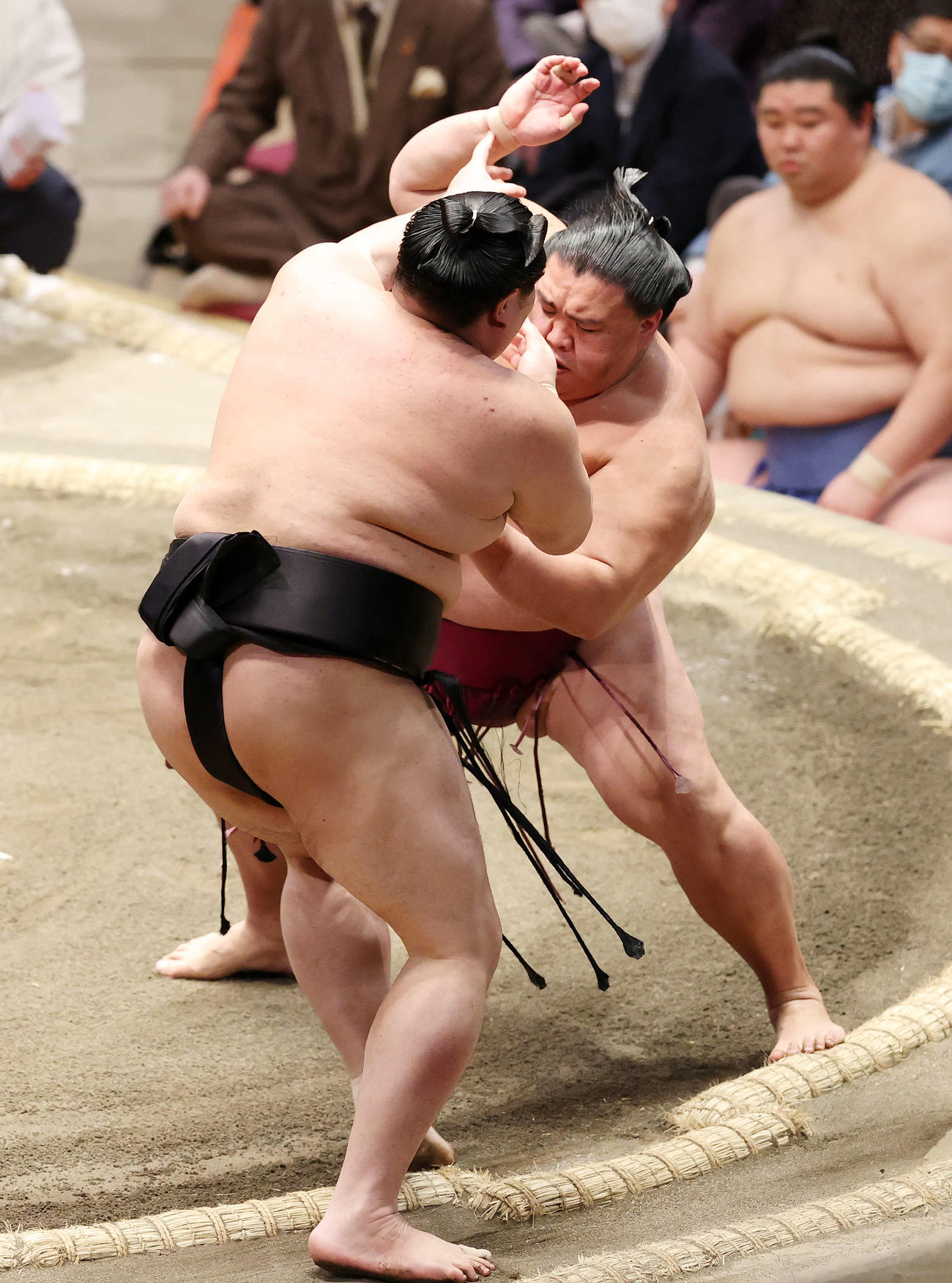 阿炎（手前）を押し出しで破る御嶽海（撮影・鈴木正人）