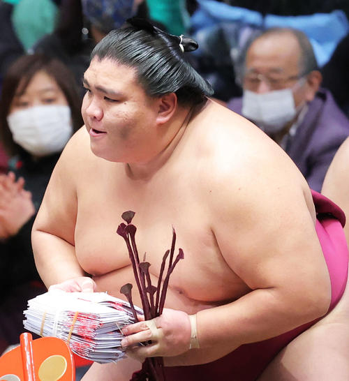 照ノ富士を寄り切りで破り幕内優勝を決め、懸賞金の束を手にする御嶽海(撮影・河田真司)