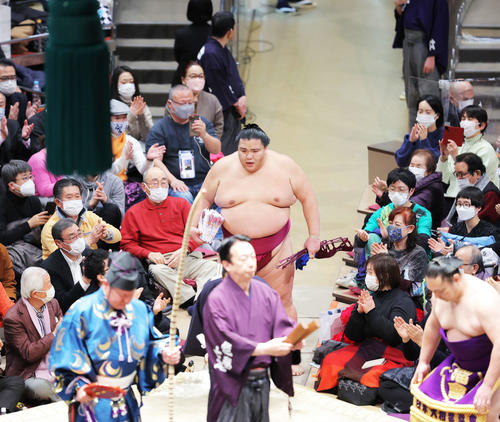 照ノ富士を寄り切りで破り幕内優勝を決め、懸賞金の束を手に土俵から引き揚げる御嶽海(撮影・河田真司)
