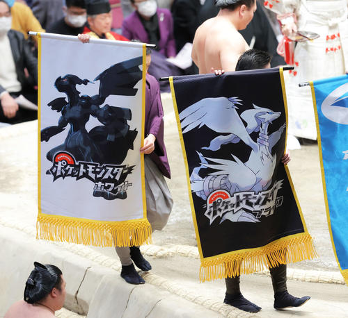 照強と北勝富士の一番で土俵を回る、ポケットモンスター「ホワイト」（左）と「ブラック」の懸賞旗（撮影・河田真司）