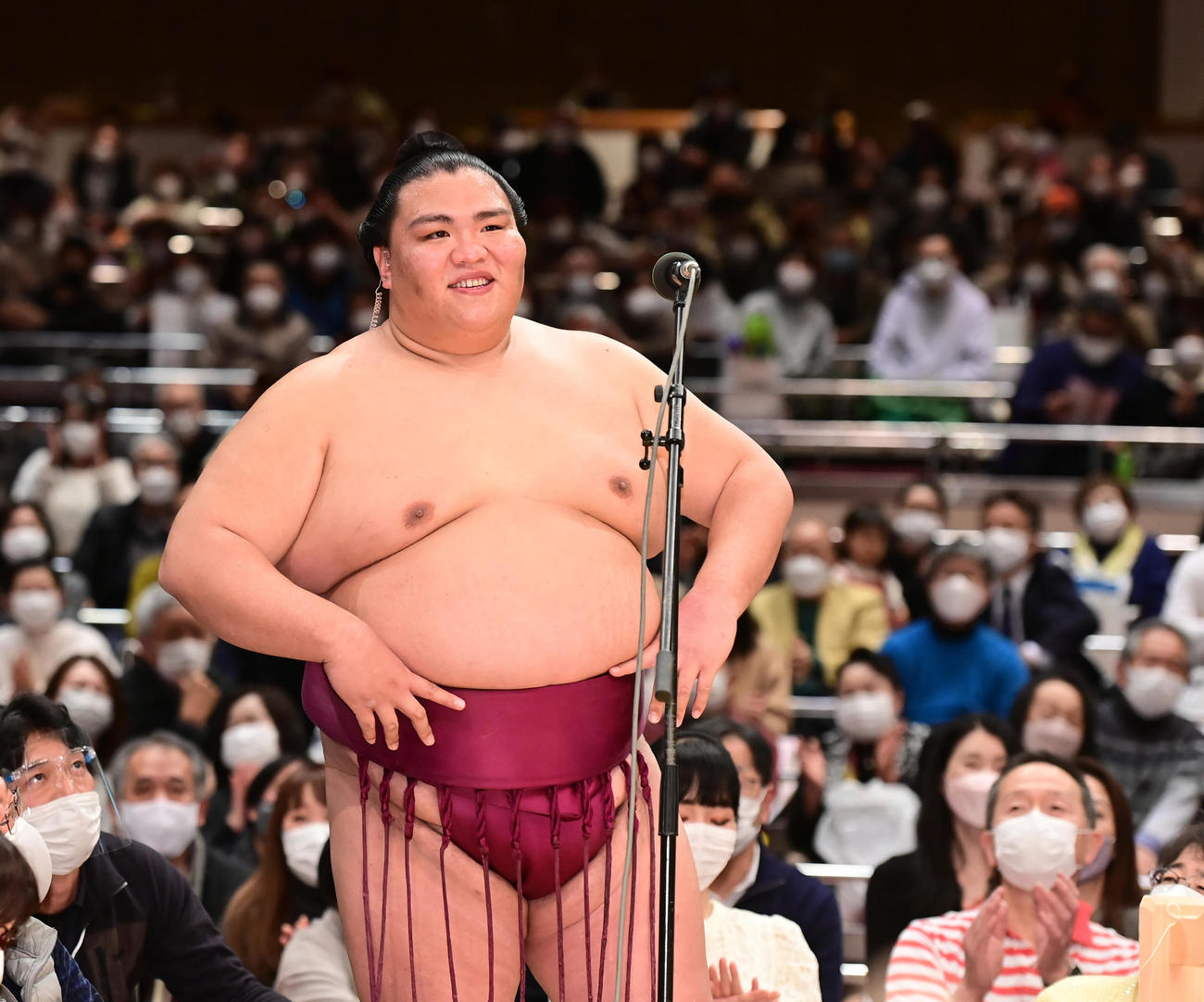 御嶽海は優勝インタビューで大関昇進をはかる臨時理事会が審判部から要請され事実上大関昇進が決まったことを伝えられると、腰に手を当てて笑顔を見せる（撮影・小沢裕）