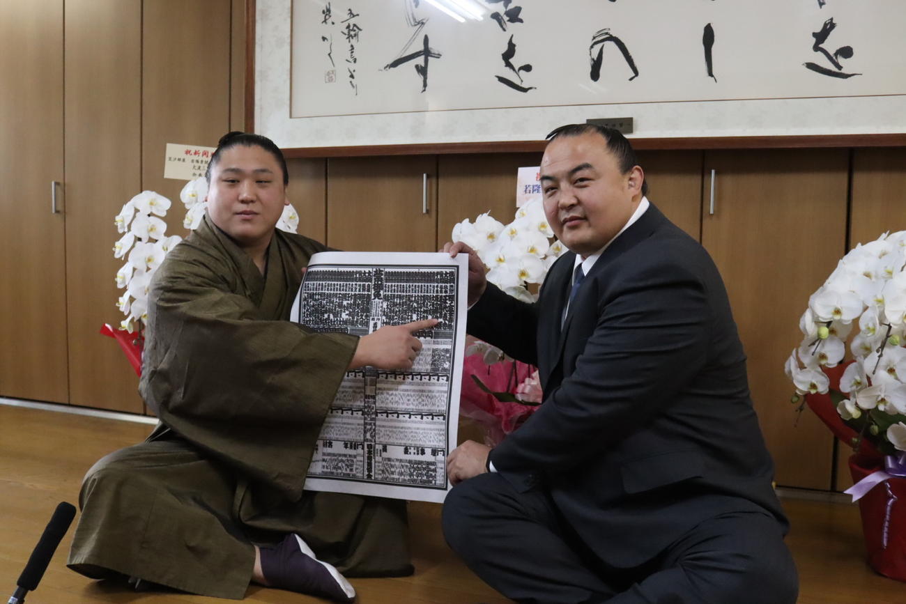 春場所の番付表に記載された自身のしこ名を指さす新関脇の若隆景（左）と師匠の荒汐親方（日本相撲協会提供）