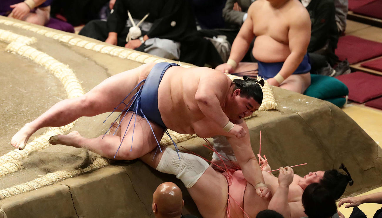 正代に押し出しで破れ土俵下に落下する宇良（右）（2022年1月10日撮影）