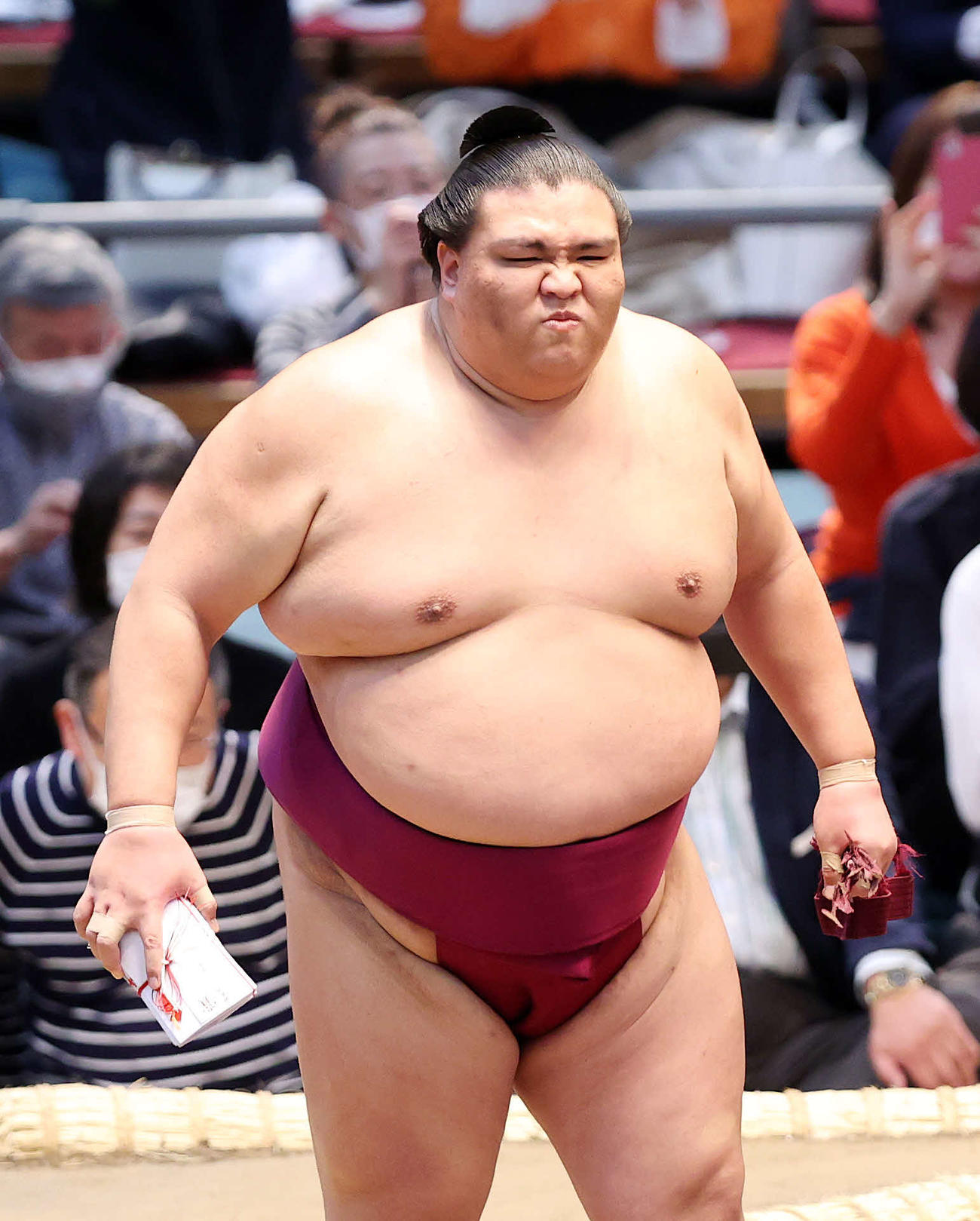 懸賞金の束を手に土俵を引き揚げる御嶽海（撮影・鈴木正人）
