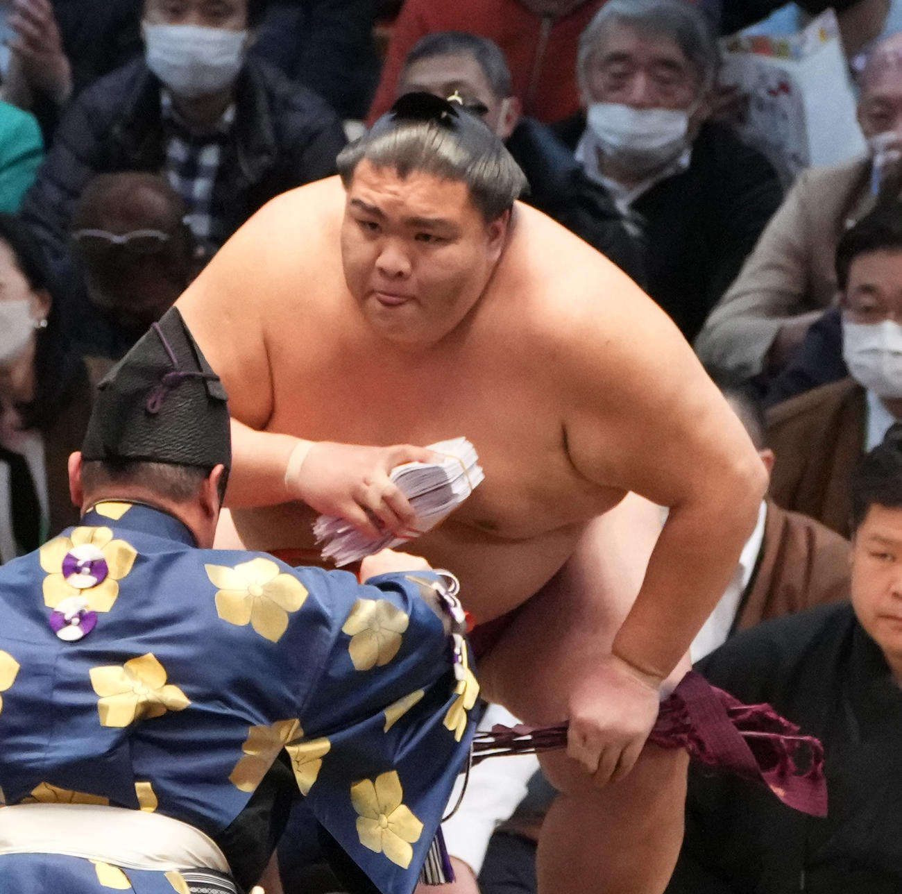 舌を出しながら懸賞金を手にする御嶽海（撮影・小沢裕）