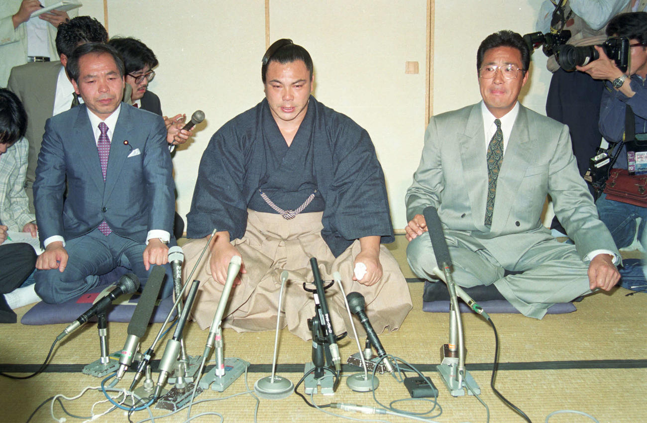 横綱千代の富士（中央）は師匠の九重親方（右）、鈴木宗男衆議院議員（左）とともに会見で引退を発表した。（1991年5月14日撮影）