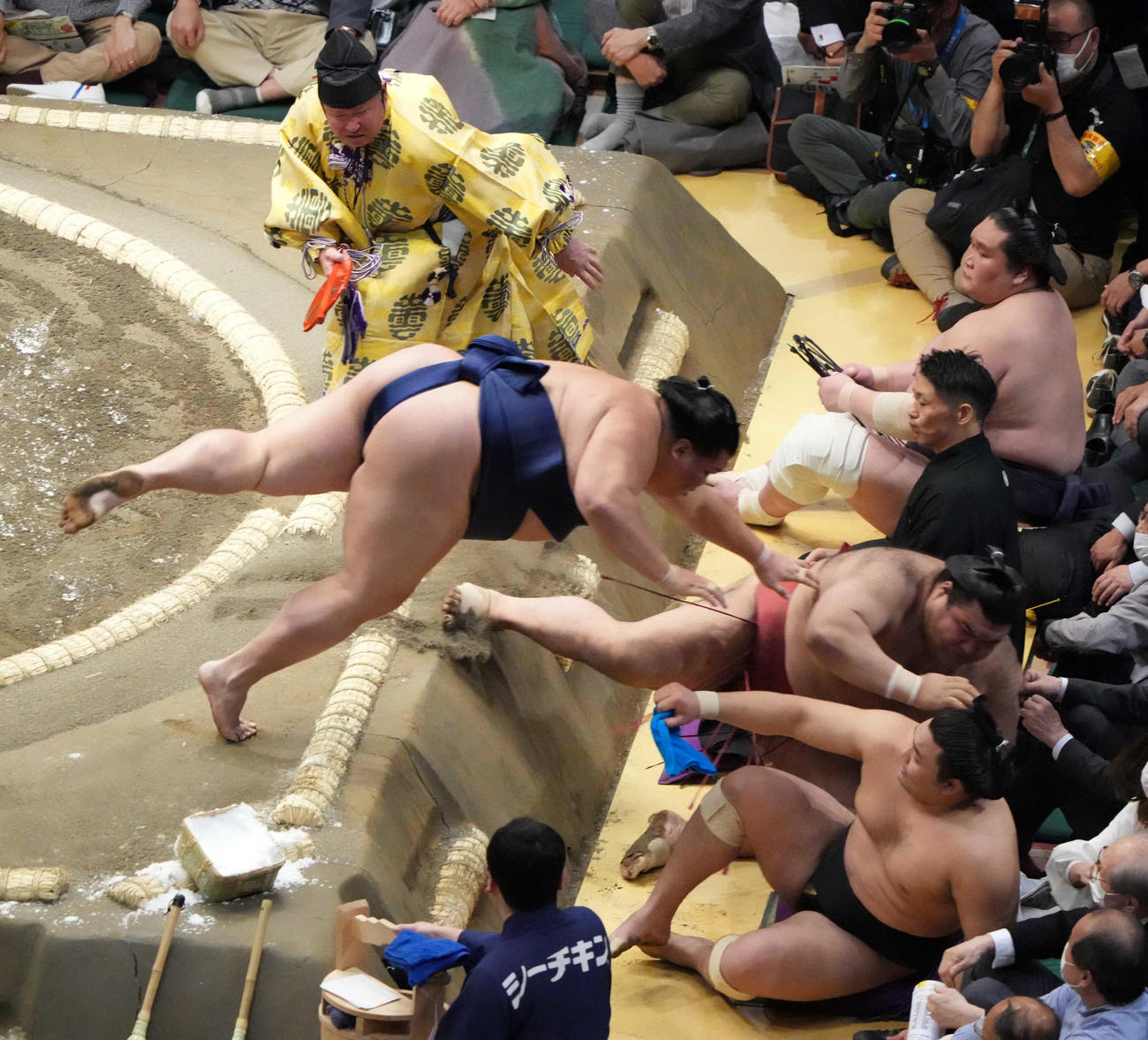 御嶽海（左）は高安を押し出しで破り土俵下へ落ちる。右は懸命に上がる行司の式守伊之助（撮影・小沢裕）