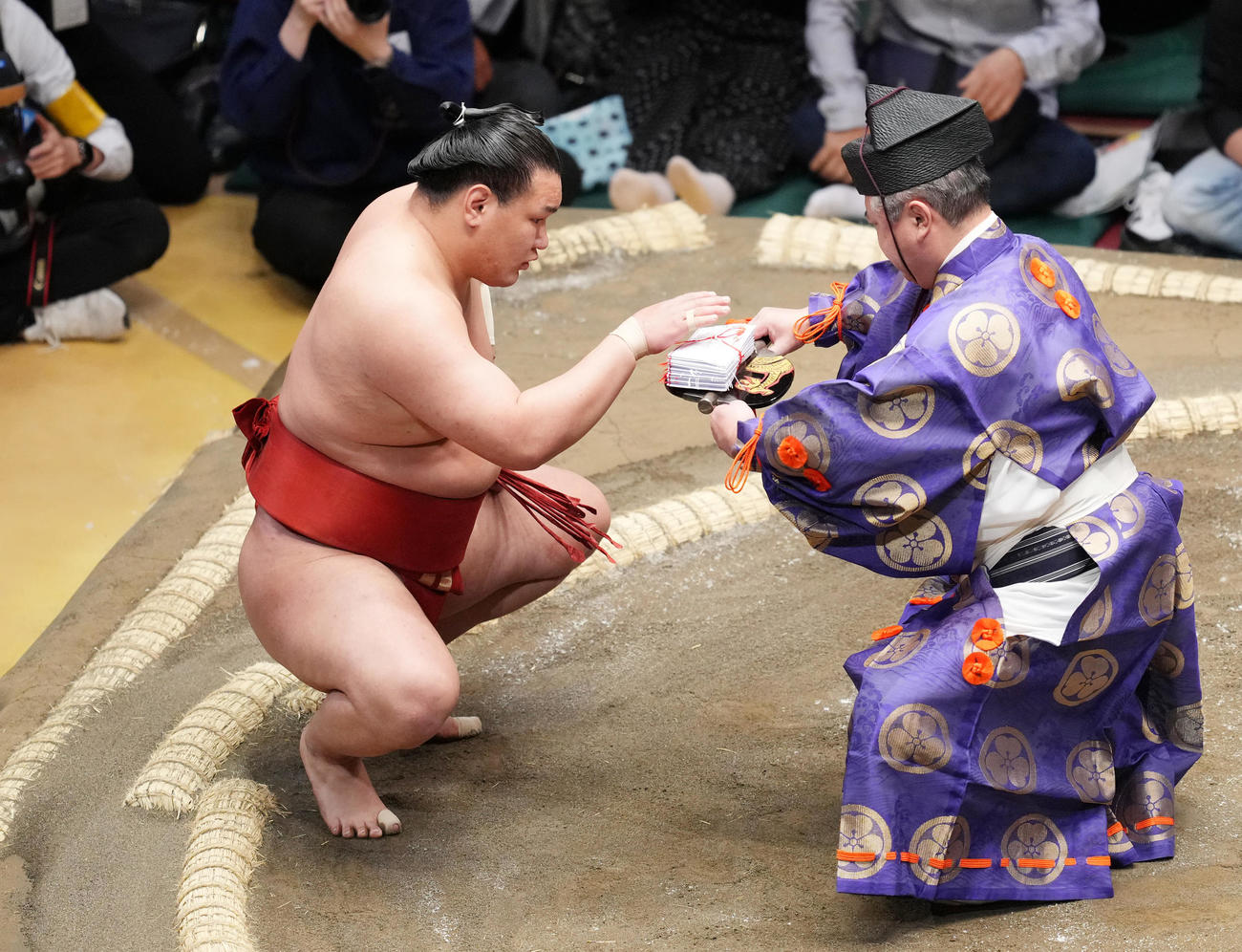 御嶽海を押し出しで破り、懸賞金を受け取る豊昇龍（撮影・菅敏）
