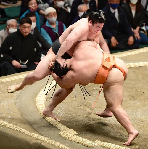 若元春（左）は志摩ノ海を上手投げで破る（撮影・小沢裕）
