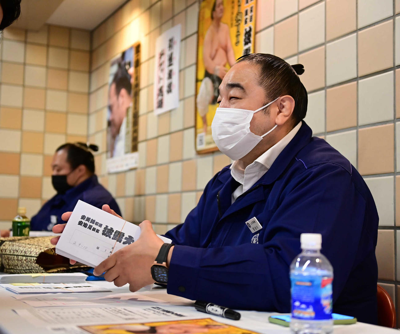館内に設置されたチケット売り場で夏場所後に行われる引退相撲のチケットを販売する元安美錦の安治川親方。奥は元豊ノ島の井筒親方（撮影・小沢裕）