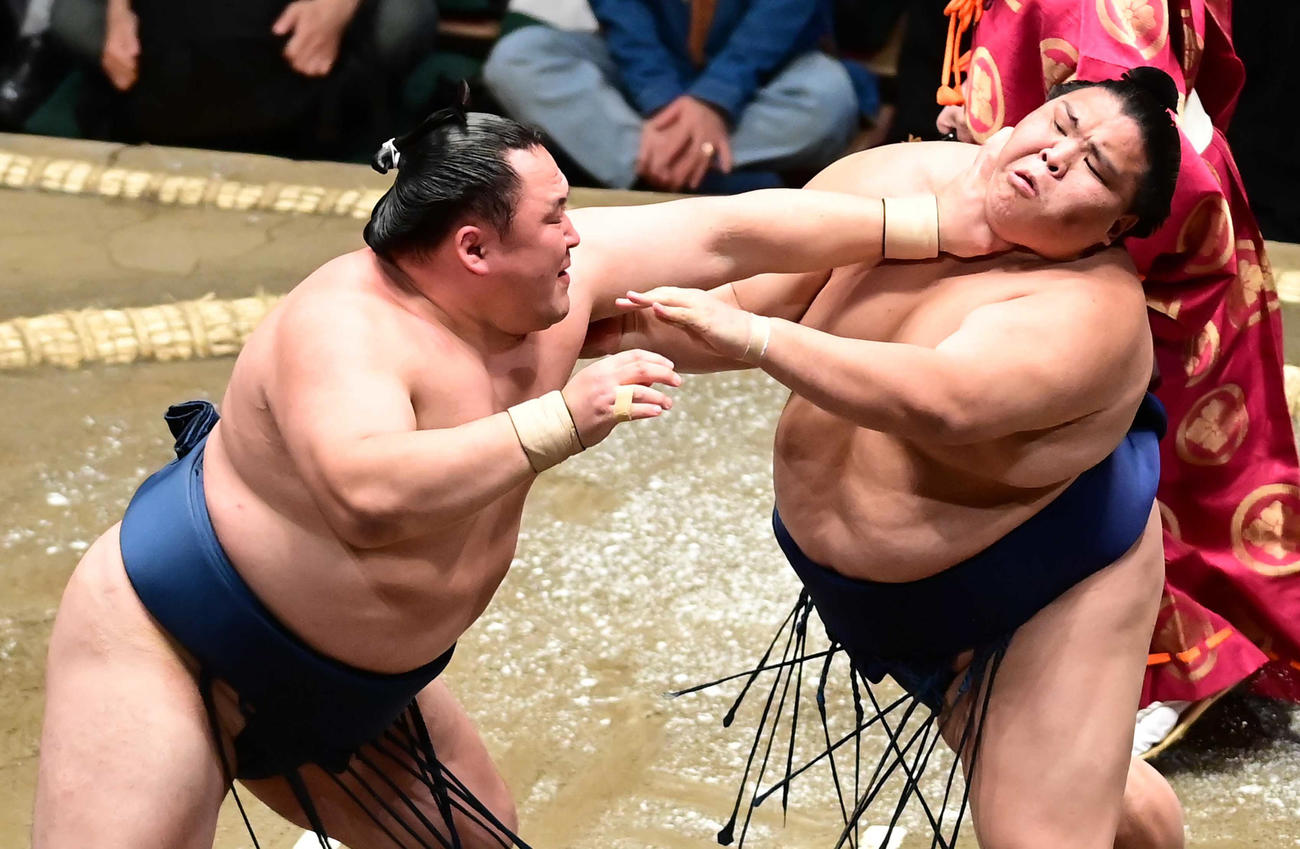 のど輪攻めで御嶽海（右）を仰け反らせる玉鷲（撮影・小沢裕）
