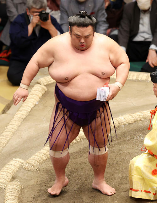 懸賞金の束を手に土俵を引き揚げる貴景勝（撮影・鈴木正人）
