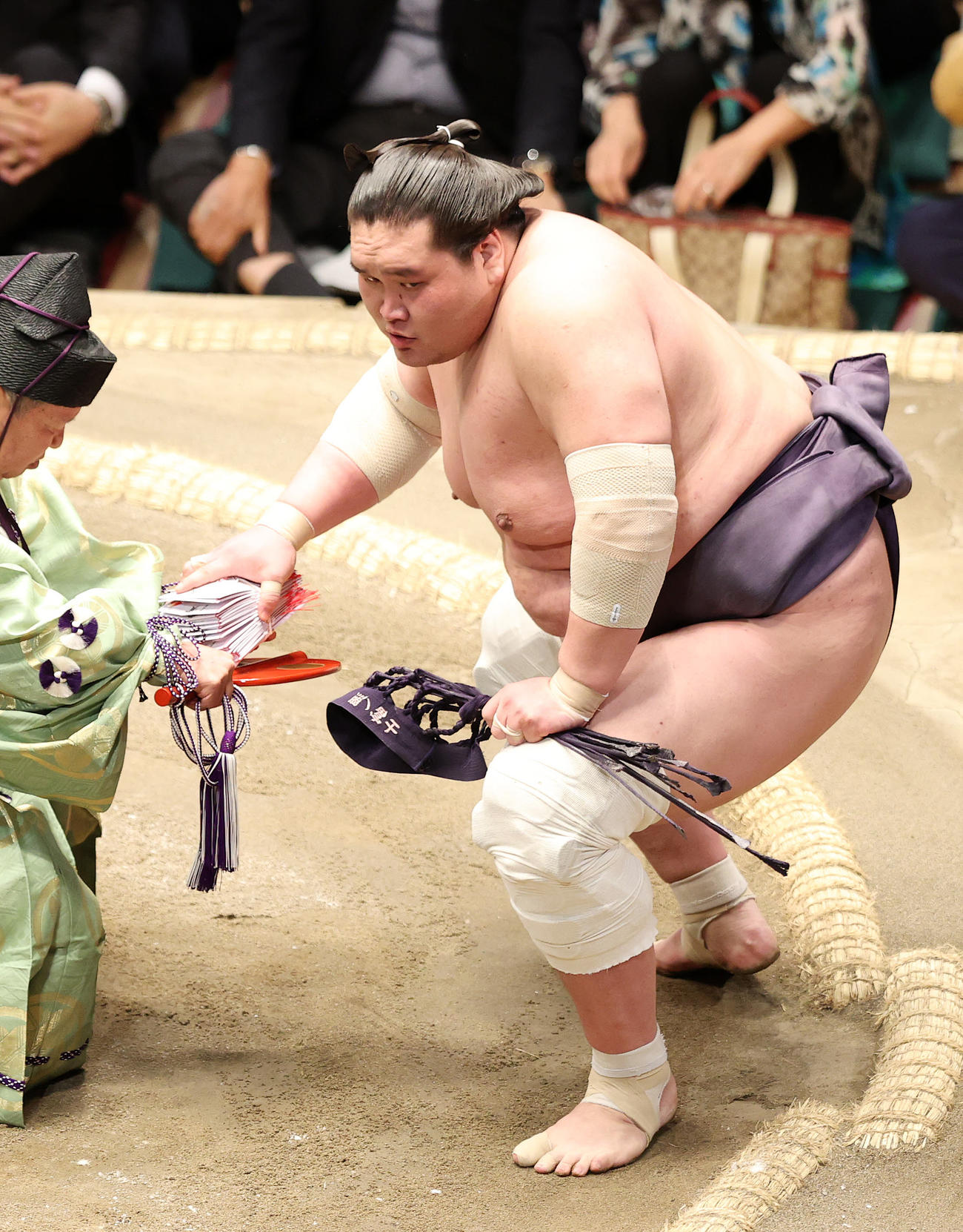 懸賞金の束を手に土俵を引き揚げる照ノ富士（撮影・鈴木正人）