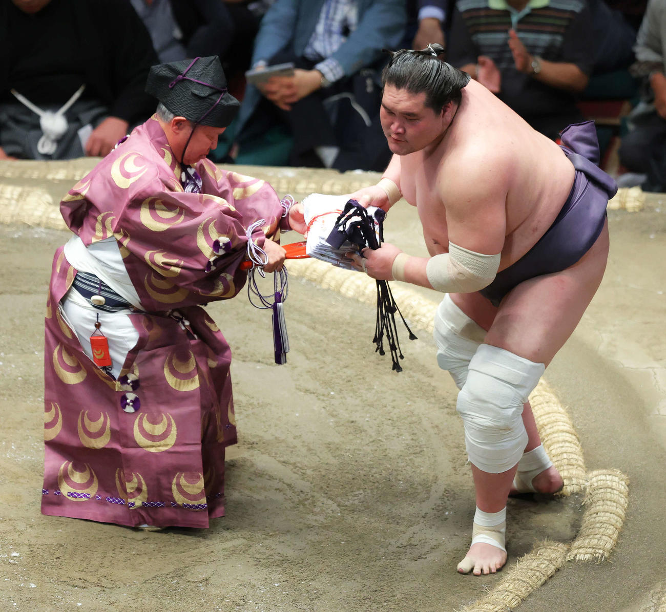 御嶽海を寄り切りで破り幕内優勝を決めた照ノ富士は、懸賞金の束を手に土俵から引き揚げる（撮影・河田真司）