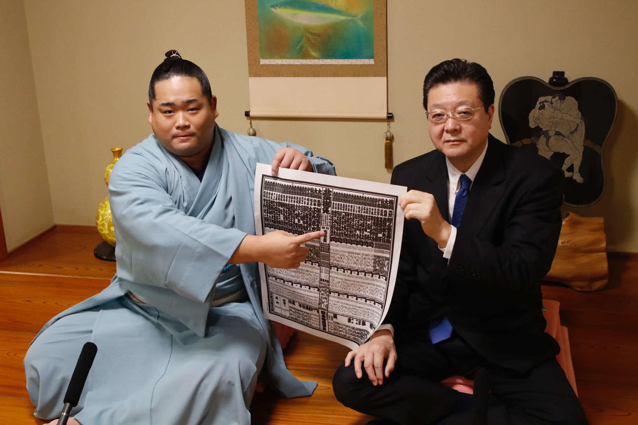 名古屋場所の番付表を持つ錦富士（左）と師匠の伊勢ケ浜親方（日本相撲協会提供）