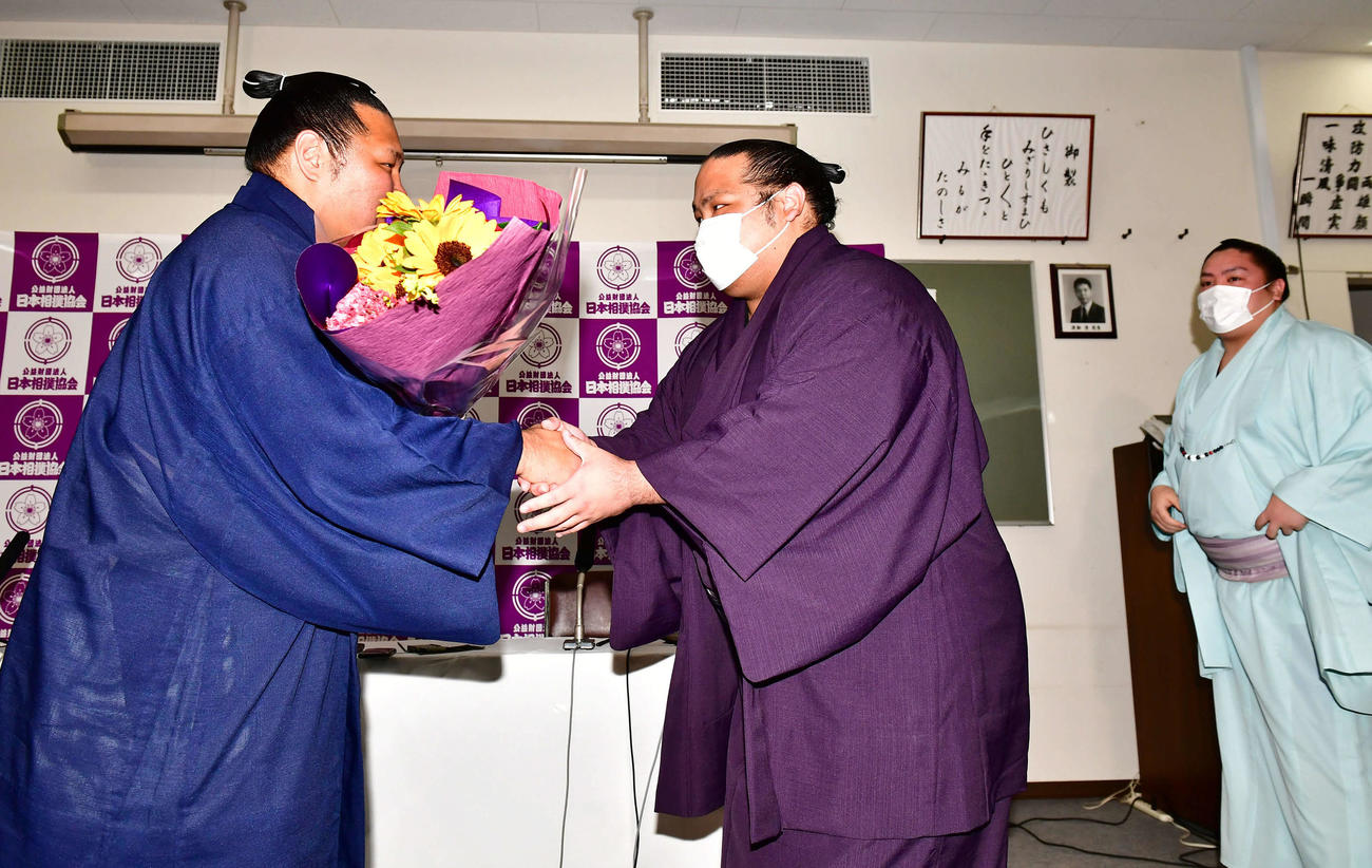 サプライズで登場し引退会見を行った松鳳山（左）に花束を贈呈する弟弟子の島津海。右は一山本（撮影・小沢裕）