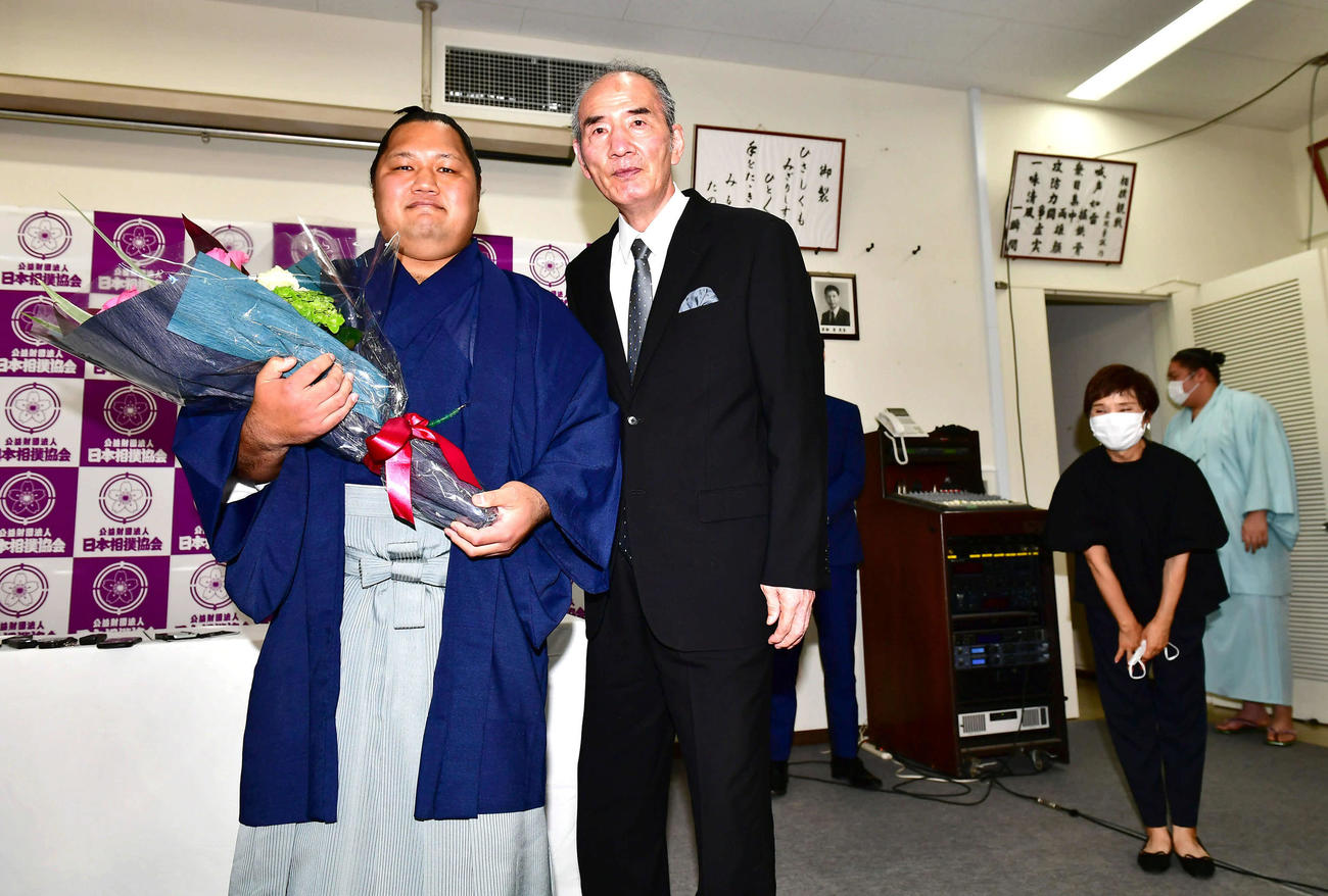 サプライズで登場し引退会見を行った松鳳山（左）に激励の花束を贈呈する先代二所ノ関親方（現荒磯、元大関若嶋津）。右奥はみづえ夫人（撮影・小沢裕）