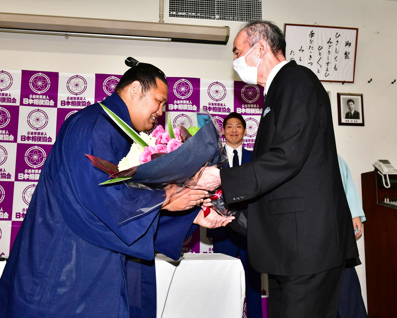 サプライズで登場し引退会見を行った松鳳山（左）に激励の花束を贈呈する先代二所ノ関親方（現荒磯、元大関若嶋津）（撮影・小沢裕）