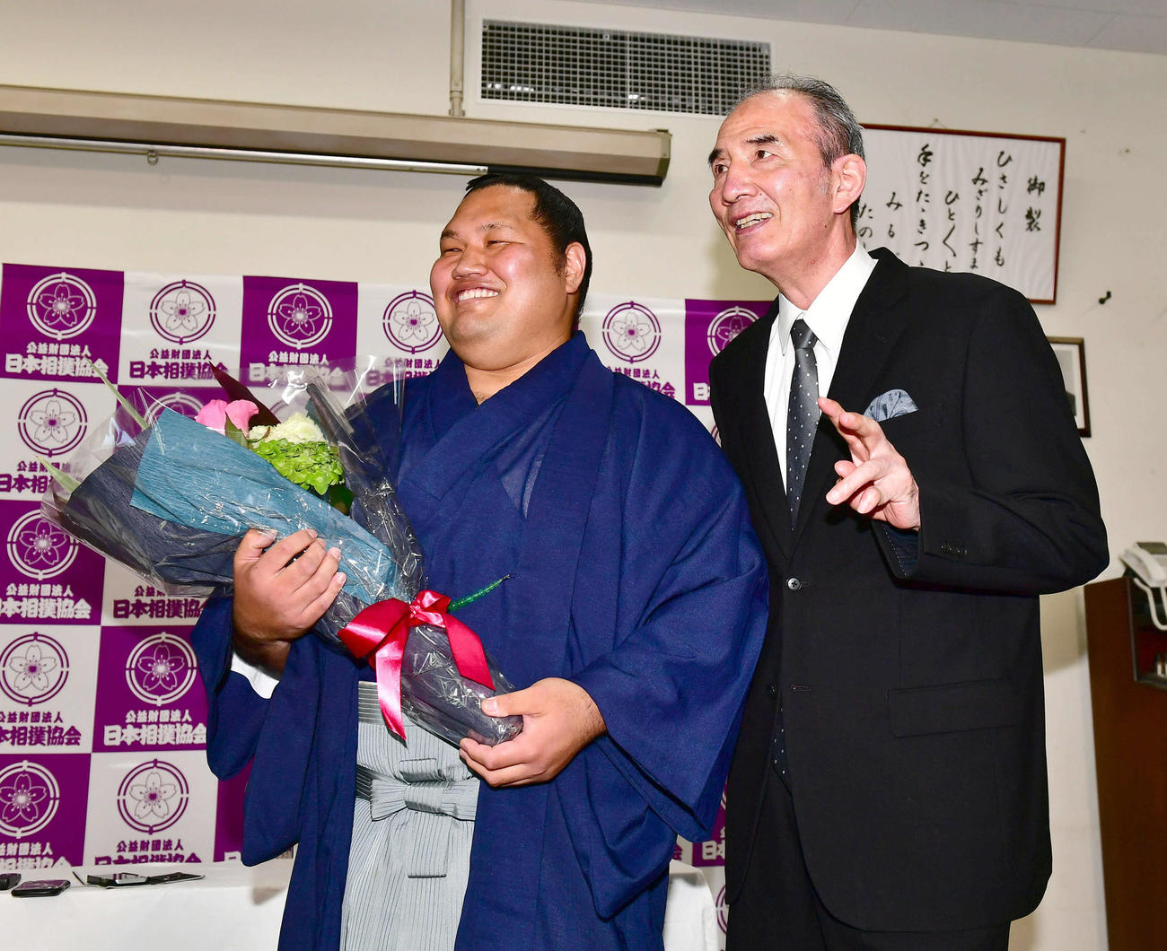 サプライズで登場し引退会見を行った松鳳山（左）に激励の花束を贈呈する先代二所ノ関親方（現荒磯、元大関若嶋津）（撮影・小沢裕）